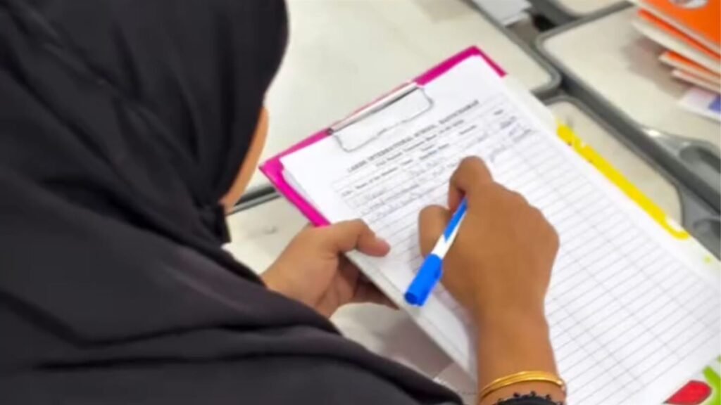 A parent signs the PTM attendance register at LAKSH International School, Razvi Chaman