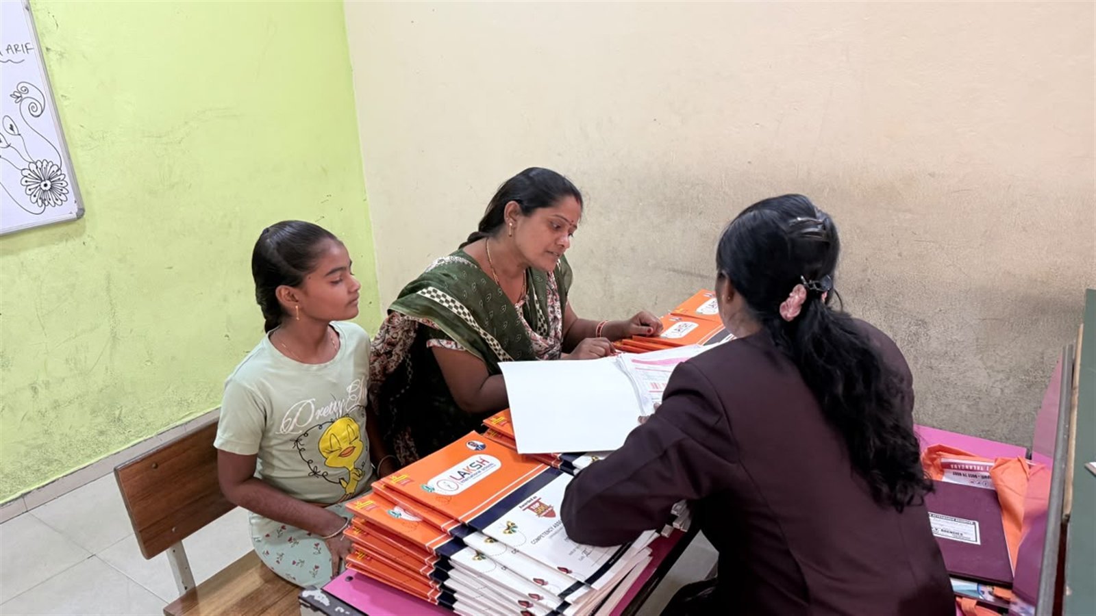 A parent and student going through a summative assessment report card with a teacher at PTM 3